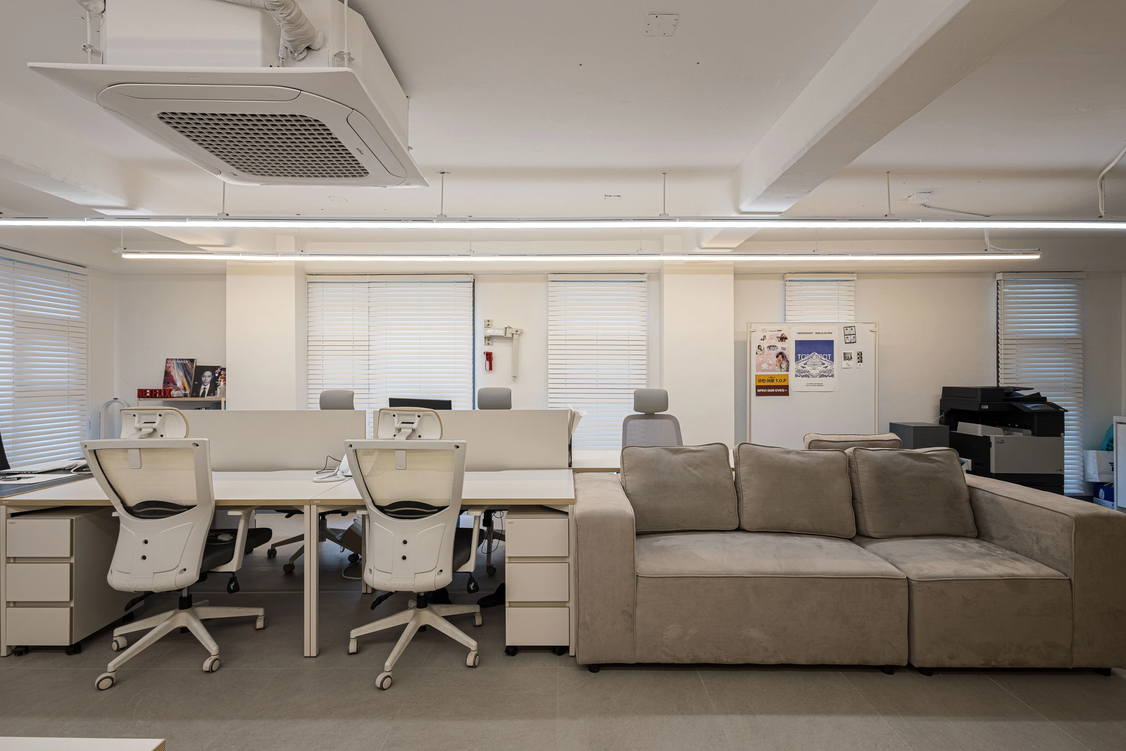Workstations and upholstered sofa beside the windows