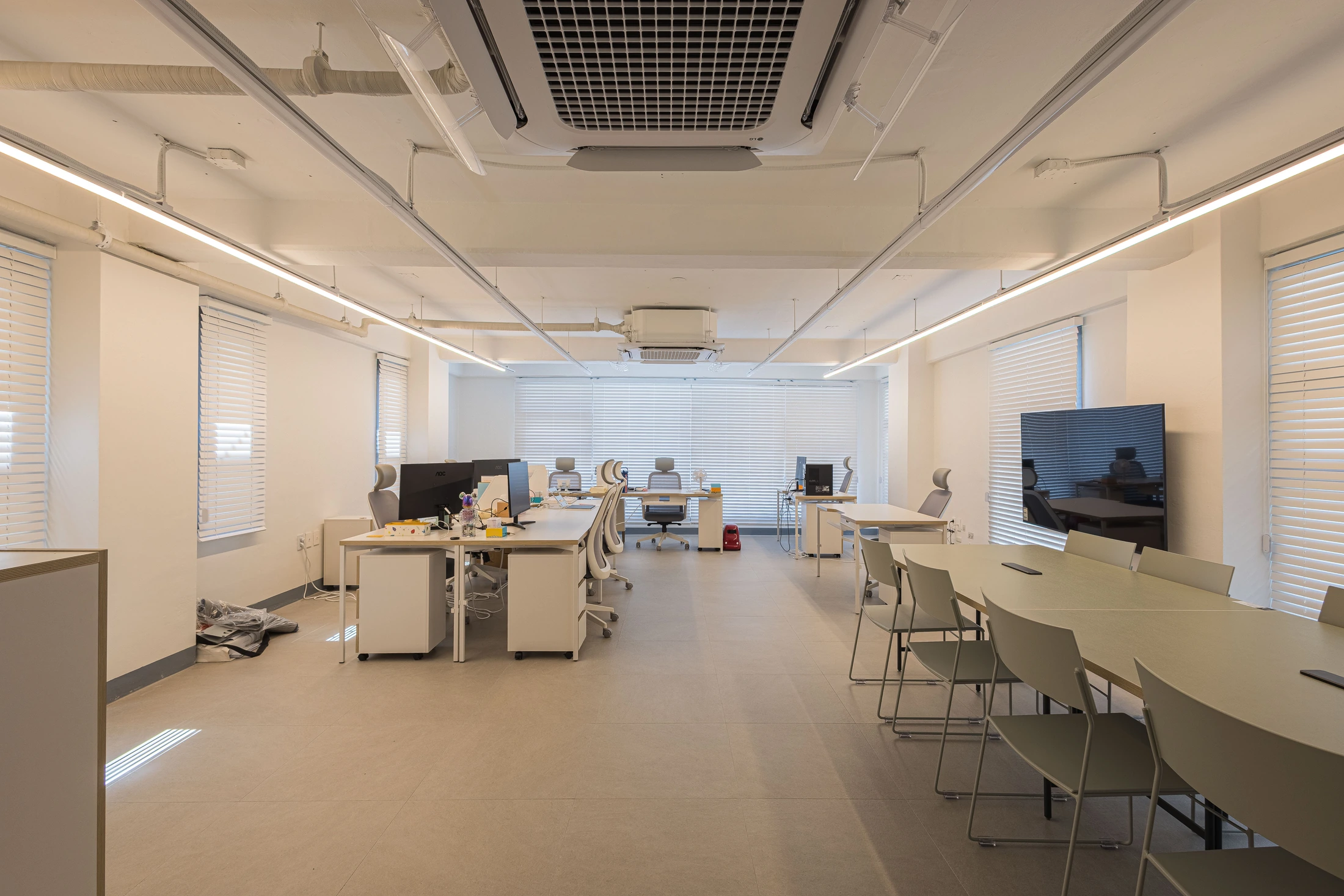 Open office with linear lighting and a shared table