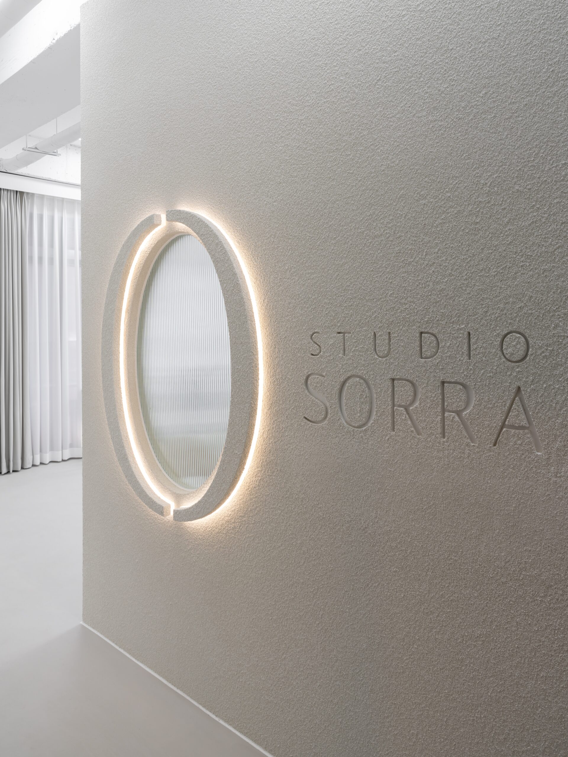 Illuminated oval mirror and engraved Studio Sorra lettering