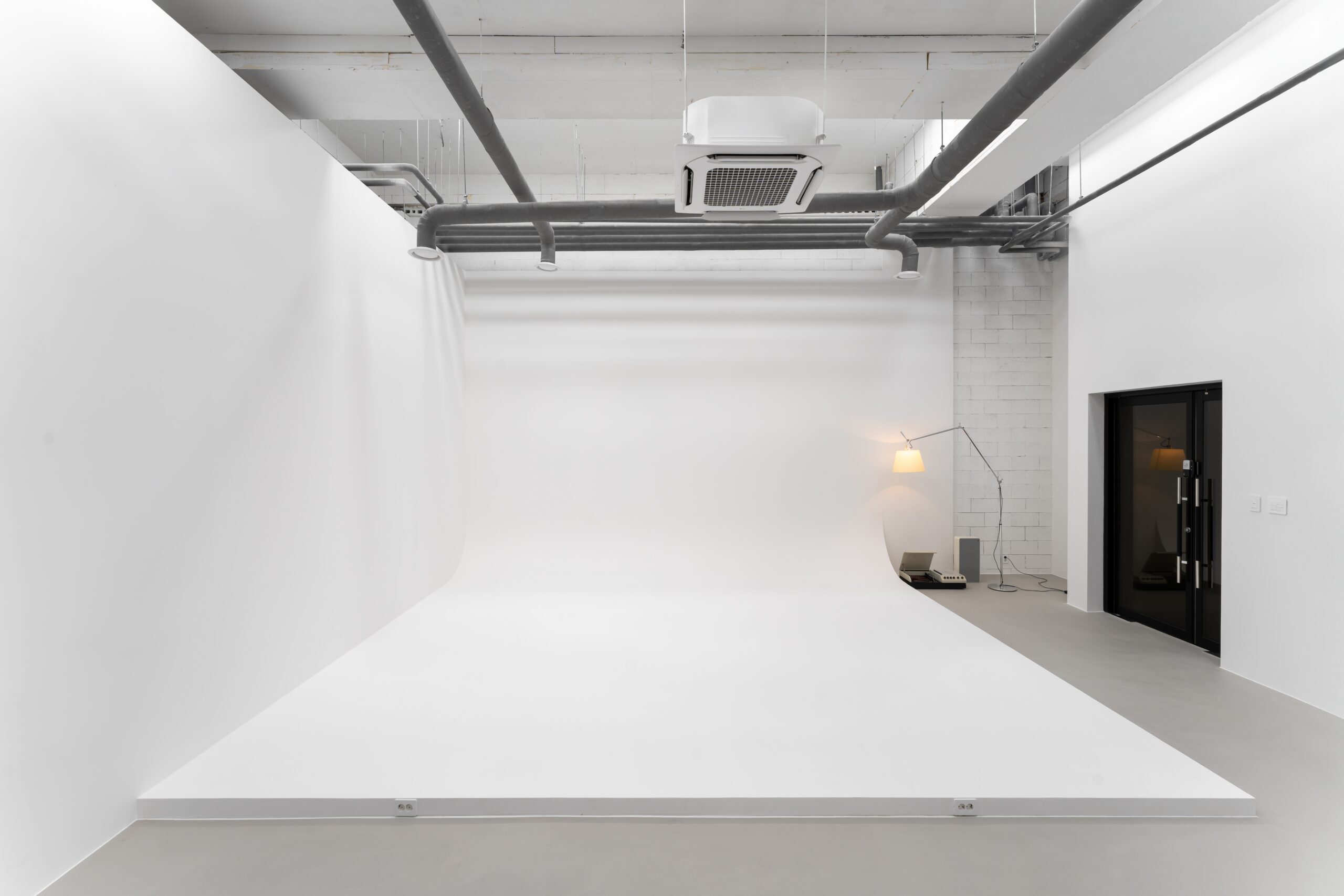White cyclorama with exposed ceiling services