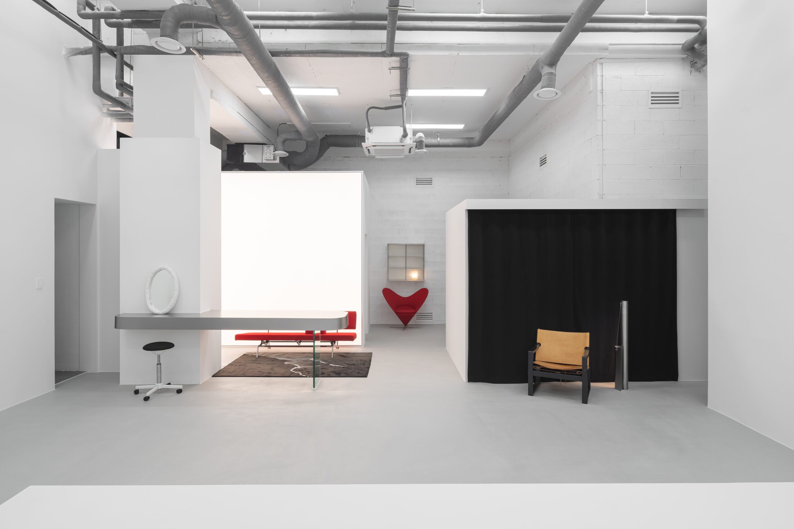 White photography studio with red seating and framed backdrop